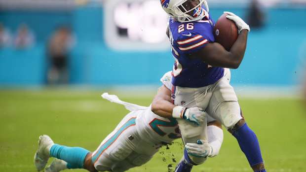 Sep 19, 2021; Miami Gardens, Florida, USA; Buffalo Bills running back Devin Singletary (26) runs with the football from Miami Dolphins safety Brandon Jones (29) during the fourth quarter of the game at Hard Rock Stadium. Mandatory Credit: Sam Navarro-USA TODAY Sports